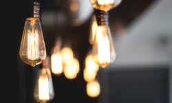 Several teardrop-shaped lightbulbs hanging from the ceiling. More bulbs are in the background, out of focus.